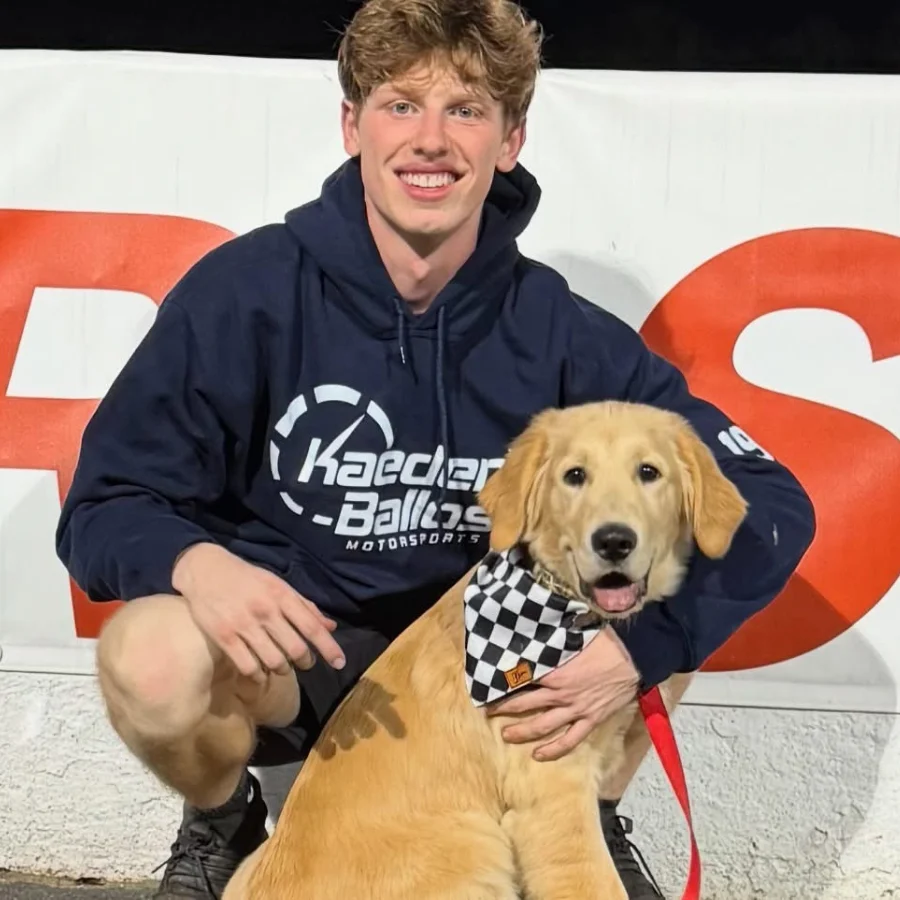 Kaeden Ballos at the track with his dog Cota, wearing team gear beside the #19 Late Model.