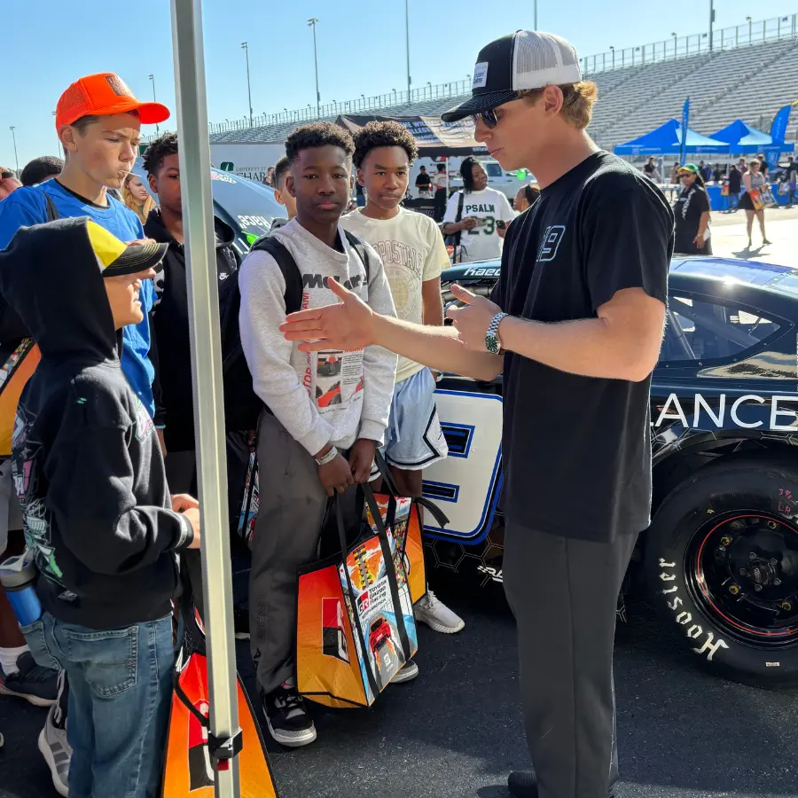 Kaeden talking with fans beside the #19 Late Model in the pits.